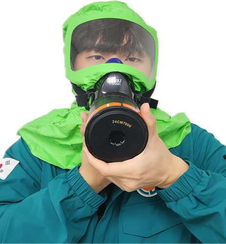 초록색 덮게 방독면을 착용후 손으로 돌리는 사진