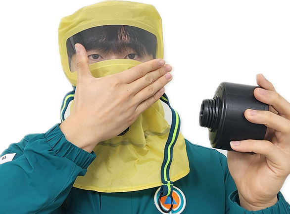 손으로 입을 가리고 정화통을 해체한 사진